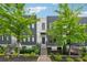 Modern two-story townhome with a black fence, landscaped yard, and stairs leading to the front door at 1106 Briar Cove Cir, Atlanta, GA 30329