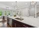 Close up view of the kitchen island and sink with pendant lights and stainless steel appliances at 1106 Briar Cove Cir, Atlanta, GA 30329