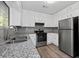 Updated kitchen features stainless steel appliances, granite counters, and white cabinets at 3193 Deshong Dr, Stone Mountain, GA 30087