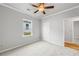 A cozy bedroom features neutral walls, carpet, a ceiling fan, and a bright window at 401 Village Ln, Fairburn, GA 30213