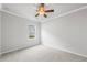 Bright bedroom with plush carpet, ceiling fan, and a window bringing in natural light at 401 Village Ln, Fairburn, GA 30213