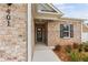 Inviting home entrance with brick facade, manicured landscaping, and modern black front door at 401 Village Ln, Fairburn, GA 30213