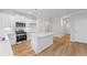 Bright kitchen with stainless steel appliances, white cabinets, island, and hardwood floors at 401 Village Ln, Fairburn, GA 30213