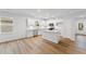 Modern kitchen featuring white cabinets, stainless steel appliances, an island, and wood flooring at 401 Village Ln, Fairburn, GA 30213