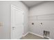 Laundry room with a large door, overhead wire shelving, and tiled floors at 401 Village Ln, Fairburn, GA 30213