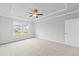Large main bedroom with a tray ceiling, fan, carpet and two windows with a view at 401 Village Ln, Fairburn, GA 30213