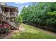 Grassy backyard featuring a staircase to a covered porch, offering ample space for outdoor enjoyment at 5025 Savannah Run, Cumming, GA 30040