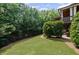 Beautiful backyard with a lush green lawn, mature trees, and a covered patio perfect for outdoor relaxation and entertainment at 5025 Savannah Run, Cumming, GA 30040