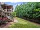 Green backyard and stairs leading to a well-kept deck area, complemented by tall, mature trees at 5025 Savannah Run, Cumming, GA 30040
