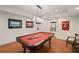 The basement features a pool table with a modern pendant lamp and a sports-themed decor adding a playful touch at 5025 Savannah Run, Cumming, GA 30040