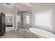Luxurious bathroom features a glass enclosed shower and a soaking tub next to a window at 5025 Savannah Run, Cumming, GA 30040