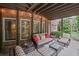 Covered patio with brick columns, ceiling fan, wicker furniture and overhead string lights at 5025 Savannah Run, Cumming, GA 30040