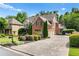 Wide driveway showcasing a beautifully landscaped home with a three-car garage and lush surrounding greenery at 5025 Savannah Run, Cumming, GA 30040