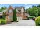 Spacious driveway leading to a three-car garage with a brick exterior and well-maintained landscaping at 5025 Savannah Run, Cumming, GA 30040