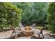 Backyard fire pit with chairs, stone base, and surrounding landscaping, ideal for outdoor gatherings at 5025 Savannah Run, Cumming, GA 30040