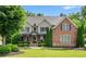 Beautiful two-story home featuring manicured landscaping, a mix of brick and stone, and a welcoming front porch at 5025 Savannah Run, Cumming, GA 30040