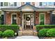 Inviting front porch with stone pillars, a decorative wreath, and manicured hedges, creating a welcoming entrance at 5025 Savannah Run, Cumming, GA 30040