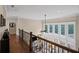 Upstairs hallway with hardwood floors overlooking a grand living space with abundant natural light at 5025 Savannah Run, Cumming, GA 30040