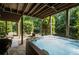 Relaxing hot tub on stone patio, complemented by outdoor seating and lush greenery at 5025 Savannah Run, Cumming, GA 30040
