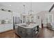 Kitchen with gray kitchen island, stainless steel appliances, wooden floors, and a view to an adjoining dining area at 5025 Savannah Run, Cumming, GA 30040