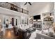 Bright open concept living room with fireplace, large windows, and a view of the second story landing at 5025 Savannah Run, Cumming, GA 30040