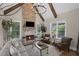 Cozy living room showcasing stone fireplace, vaulted ceiling with wooden beams, and large windows at 5025 Savannah Run, Cumming, GA 30040
