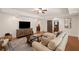 Cozy living room with a large sectional sofa, wood floors, TV and ceiling fan at 5025 Savannah Run, Cumming, GA 30040