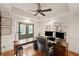 Bright home office features a tray ceiling, hardwood floors, built-in bookshelves, and double glass doors at 5025 Savannah Run, Cumming, GA 30040