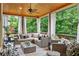 Relaxing covered porch with stylish outdoor furniture, a ceiling fan, and wooded views at 5025 Savannah Run, Cumming, GA 30040