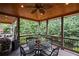 Cozy covered porch with a dining area, ceiling fan, and scenic wooded views at 5025 Savannah Run, Cumming, GA 30040