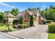 Spacious driveway and manicured lawn with lush landscaping surrounding the brick house at 5025 Savannah Run, Cumming, GA 30040
