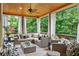 Relaxing screened porch with wicker furniture and scenic views of the surrounding trees at 5025 Savannah Run, Cumming, GA 30040
