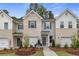 Charming townhome exterior with brick and gray siding, complemented by a well-manicured lawn and inviting landscaping at 316 Navigator Ln, Mcdonough, GA 30253
