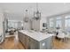 Open-concept kitchen with island seating, modern lighting, and seamless flow to living and dining areas at 392 Concord St, Alpharetta, GA 30009