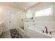 Bright bathroom featuring a glass enclosed shower, soaking tub and decorative rug at 4832 Stone Way Path, Buford, GA 30519