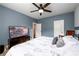 Well-lit bedroom with a large TV, stylish decor, and a comfortable bed with decorative pillows at 4832 Stone Way Path, Buford, GA 30519