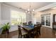 Dining room with hardwood floors, wainscoting, chandelier, and view to patio at 4832 Stone Way Path, Buford, GA 30519