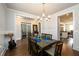 Dining room featuring hardwood floors, wainscoting, stylish chandelier, and view to kitchen at 4832 Stone Way Path, Buford, GA 30519