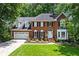 Stately brick home with lush front lawn, two car garage, and professionally landscaped flower beds at 763 Old Paper Mill Se Dr, Marietta, GA 30067