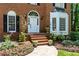Charming front porch entrance to a home with steps, urns, and a beautifully landscaped garden at 763 Old Paper Mill Se Dr, Marietta, GA 30067