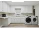 Well-organized laundry room with white cabinetry, sink, and modern washer and dryer units at 112 Pioneer Trail, Cartersville, GA 30121