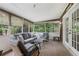 Comfortable screened porch with wicker furniture, ceiling fan, and view of wooded backyard at 112 Pioneer Trail, Cartersville, GA 30121
