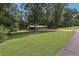 Wide view of house nestled among mature trees with large grassy yard at 112 Pioneer Trail, Cartersville, GA 30121