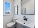 White powder room features a pedestal sink, black faucet, and window view at 1725 Lansmere Sw St, Marietta, GA 30008