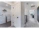 Hallway leading to a laundry room with modern appliances and overhead storage at 1725 Lansmere Sw St, Marietta, GA 30008