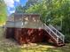 Back deck with stairs and white railing overlooking green foliage at 2030 Carr Rd, Conyers, GA 30012