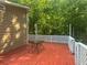 Back deck with a table and white railing overlooking green foliage at 2030 Carr Rd, Conyers, GA 30012