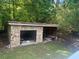 Open stone outbuilding with a yard and green foliage in the background at 2030 Carr Rd, Conyers, GA 30012