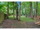 Grassy backyard is surrounded by mature trees and lush greenery, providing a private retreat at 2766 Stonecreek Se Rd, Smyrna, GA 30080