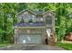 Charming two-story home features a brick facade, arched window, and a two-car garage nestled among mature trees at 2766 Stonecreek Se Rd, Smyrna, GA 30080